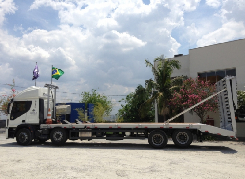 Este caminhão para transporte de cargas pesadas tem uma capacidade útil de 8,90 metros de comprimento e carrega um máximo de 15 toneladas, além de possuir rampa de acesso traseiro em aço com acionamento hidráulico.