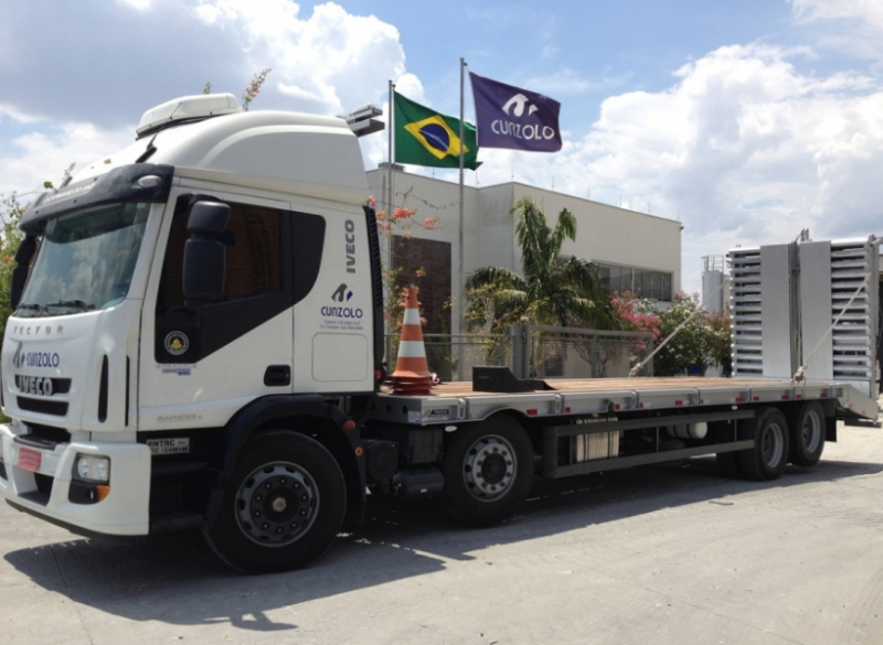 Este caminhão para transporte de cargas pesadas tem uma capacidade útil de 8,90 metros de comprimento e carrega um máximo de 15 toneladas, além de possuir rampa de acesso traseiro em aço com acionamento hidráulico.
